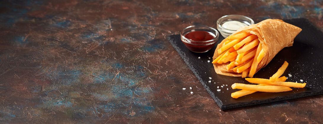 酱汁美味的薯条和酱汁在石板切割板上美食土豆薯条