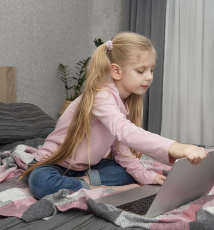 连接金发女孩在家上网学习 床上放着笔记本电脑学习学校卧室