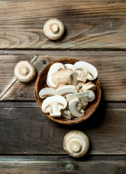 整个鲜蘑菇片碗开木桌健康可食堆