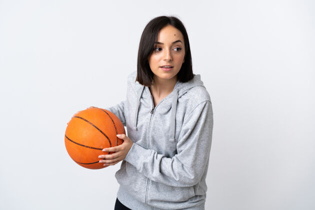 青年年轻的白人女子孤身在白墙上打篮球运动员女孩黑发