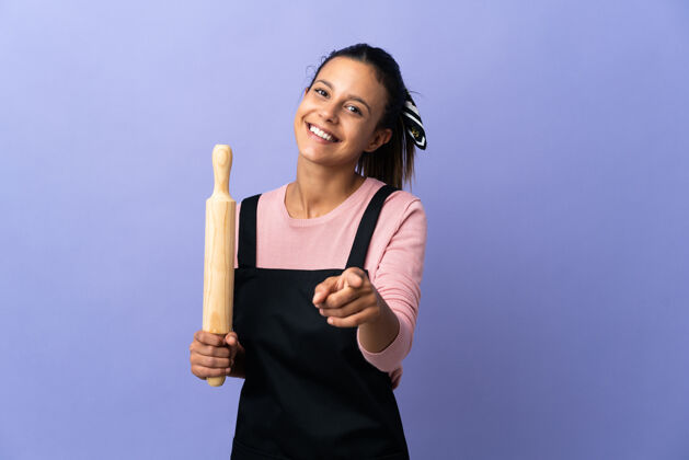 厨师身着厨师制服的年轻女子用幸福的表情指着前面惊喜快乐面包