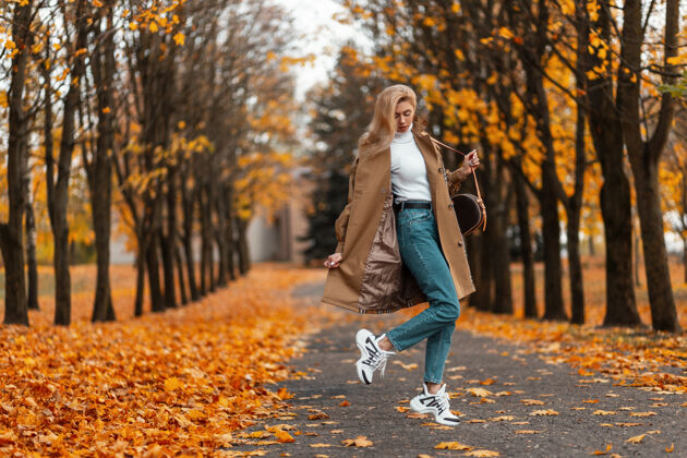 秋天一个穿着优雅外套的时髦发型的年轻女子在公园的户外摆姿势户外模特鞋子