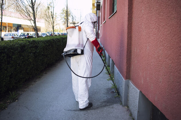传染病穿着防化服在公共场所喷洒消毒剂的不知名工人传染病药品预防