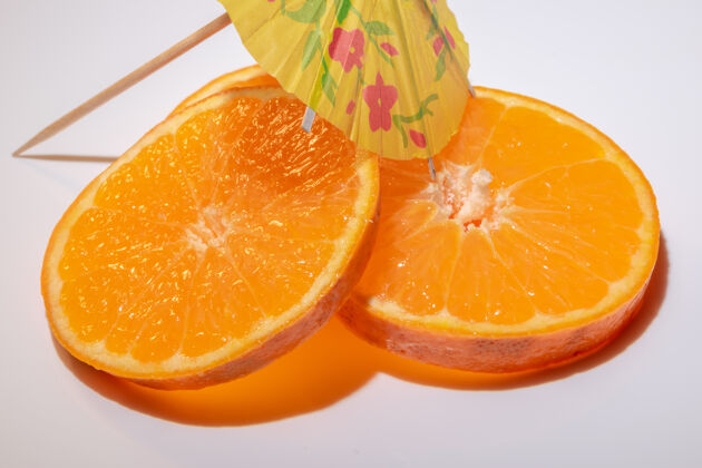 柑橘用鸡尾酒伞在白色背景上分离的克莱门汀水果片柑橘块叶子