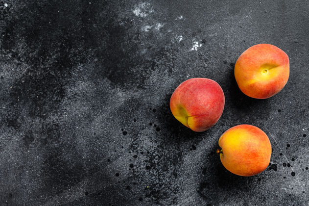 可口新鲜的桃子和水果放在深色的木制背景上顶部查看.复制空间团体花园甜味