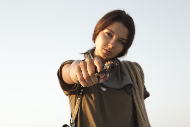 成人站在户外的一个女人 手里拿着枪和绳子沙漠.portraint一个年轻的野蛮人特工