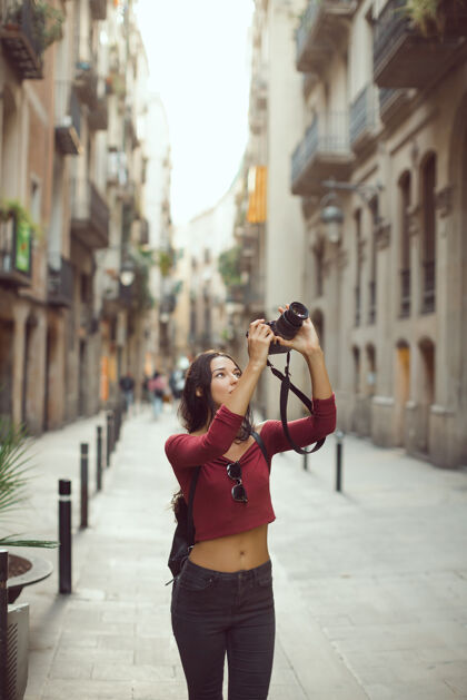 白种人迷人的旅游女摄影师拍摄的单反相机在户外的城市街道上女孩旅游快乐
