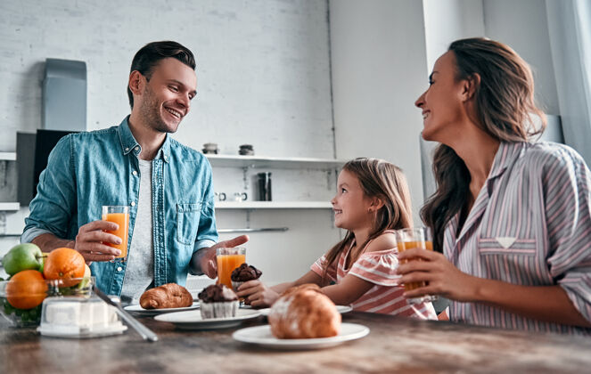 厨房妈妈 爸爸和他们漂亮的小女儿在厨房吃早餐 然后说吧开心家庭观念水果团聚家庭