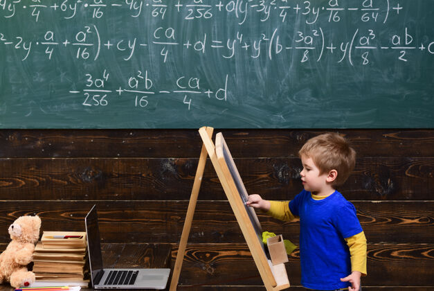 泰迪熊小孩子在上面写字黑板孩子在黑板前学数学方程式.smart学习数学的学生转身玩具聪明