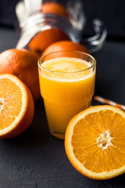 生的一张黑桌子上放着新鲜的橙汁和橙子柑橘果汁刷新