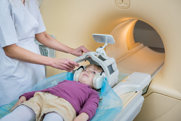 技师放射科医生准备给小女孩做核磁共振脑部检查实验室放射实践