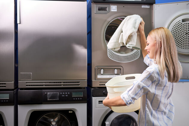 脏年轻女性从洗衣机里拿出干净的衣服 人们的生活方式概念.清洁 洗衣服家庭主妇家务清洁