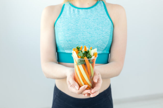 吃健活方式的特写镜头女人拿着蔬菜在室内零食看景点