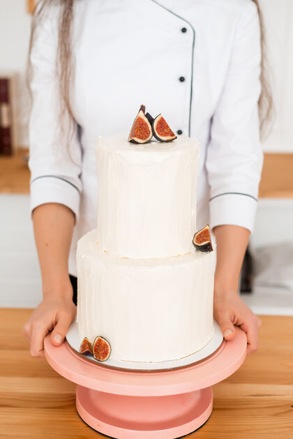 桌子蛋糕在主人手里有两层婚礼厨师无花果白蛋糕庆祝餐厅烹饪