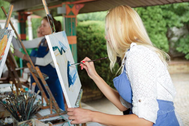 水美丽的金发女画家 手里拿着画笔 在大自然的画布上画画人物女性爱好