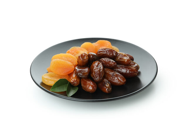 卡里姆盘子里放着干枣和杏子 放在白色的盘子里浆果干枣