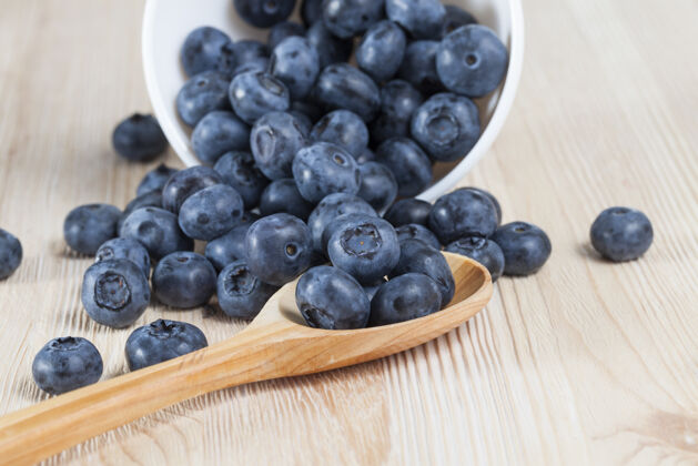 膳食成熟的蓝莓 躺在桌子上和木勺里 春天特写谎言素食者零食