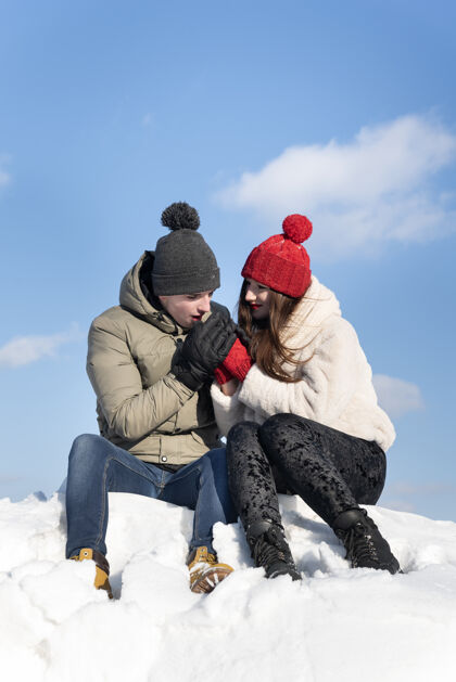 女朋友这对恩爱的情侣坐在蓝色的雪地上天啊 伙计温暖他心爱的人的手爱情男人温暖