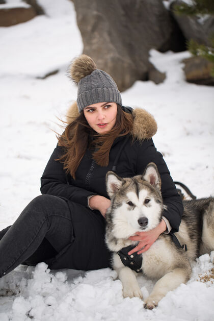 假日冬天森林里美丽的女孩狗玩和狗西伯利亚哈士奇美丽乐趣玩耍