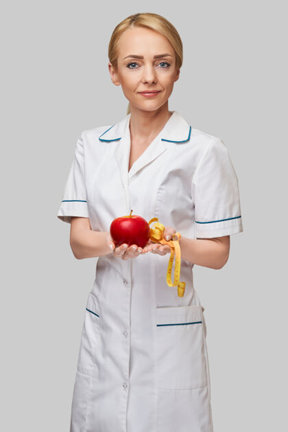 工作营养师医生健康的生活方式概念-持有有机红苹果和卷尺医务工作者营养师水果