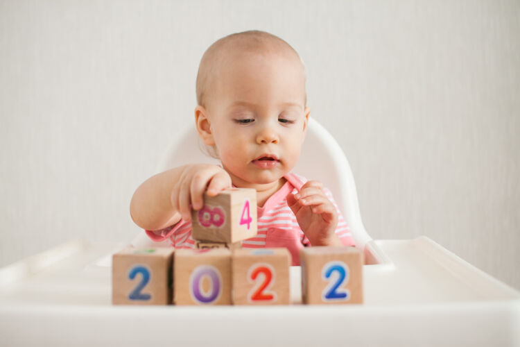 活动小女孩在玩木头方块 上面有明亮的数字2022逻辑建设宝贝