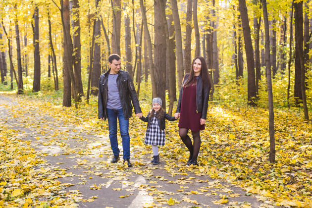 户外为人父母 秋天和人的概念-年轻的家庭在秋天公园快乐秋天童年秋天