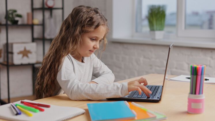 居家女学生在做作业 敲键盘键盘.距离学习在线儿童家庭教育课程讲座交流