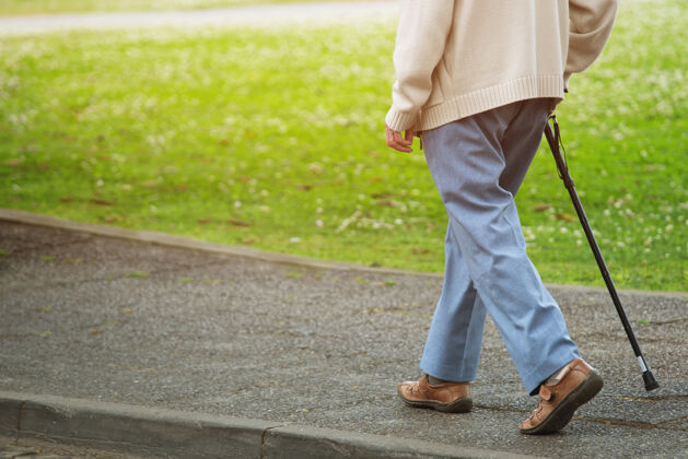 动作老人拄着手杖站在人行道上 独自过街 在公园的路边人行横道孤独腿