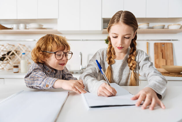 解释协助孩子善良聪明可爱的妹妹写下一些东西 帮助她的弟弟完成家庭作业 而他们都花时间在家里兄弟教育识字