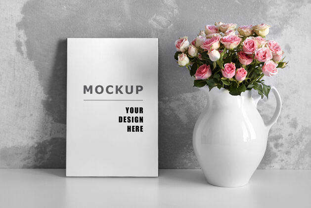 模型白色桌子上的空白帆布模型 灰色墙壁背景上的花瓶里有粉色的花混凝土灰色艺术家
