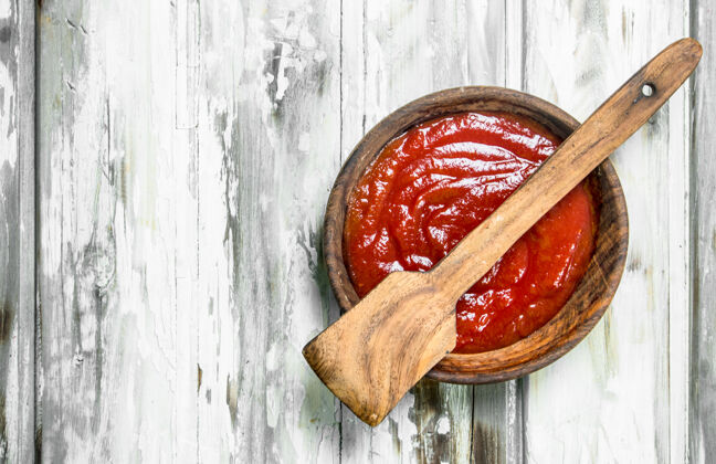 红色用勺子把番茄酱放在木碗里新鲜美食酱汁
