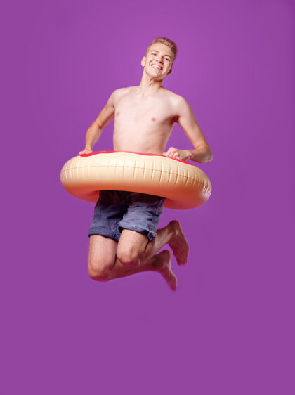 充气男子跳进紫色的游泳圈 动作游泳池肖像快乐