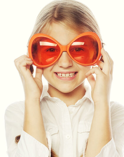 托儿所快乐的小女孩 戴着有趣的橙色康乃馨眼镜好看脸头