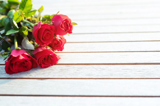 花束木桌上的红玫瑰心日期礼物