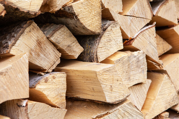 木材背景是从木柴堆起的桦树 用于暖气房 堆放在后院 未切割的木头 桦树棕色粗糙热