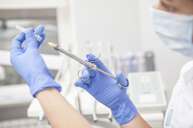 注射一个女牙医为病人准备麻醉注射器的特写镜头医院职业工人