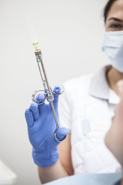 止痛药女牙医手中麻醉注射器的特写镜头制药保健手套