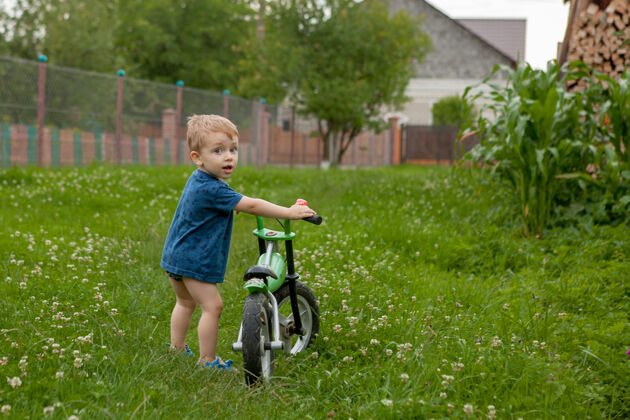 生活方式一个可爱的小男孩在家附近骑着自行车 一项儿童运动 一个活跃的家庭在街上享受安全原创