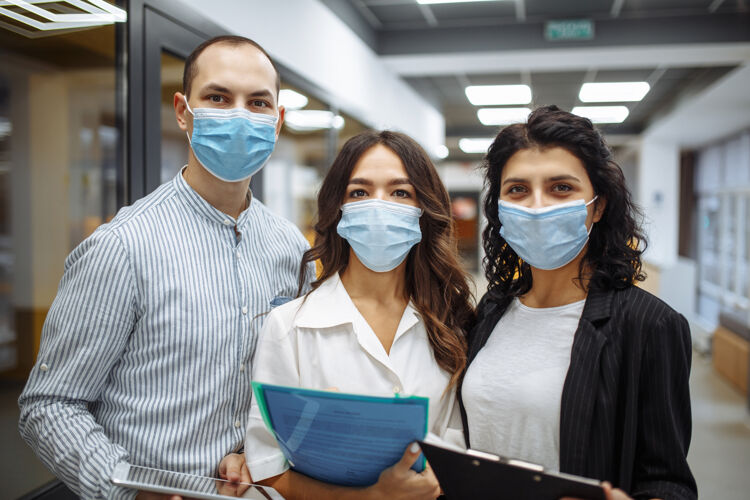 流行病三个戴着医用口罩的上班族的画像 讨论着生意和未来的前景文件工作病毒