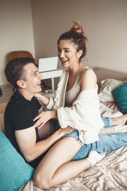 浪漫可爱的年轻夫妇躺在床上拥抱 微笑着在周末丈夫室内美丽