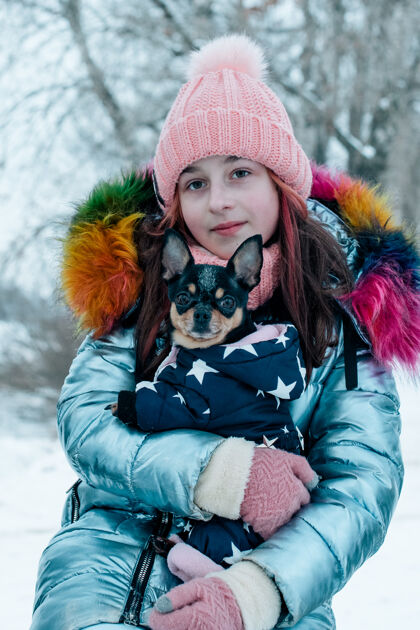 寒冷漂亮的女孩 脸上挂着吉娃娃自然青少年女孩和吉娃娃在冬天的街上动物青少年青少年