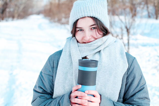 野餐戴着热水瓶帽的年轻女人凉爽围巾温暖