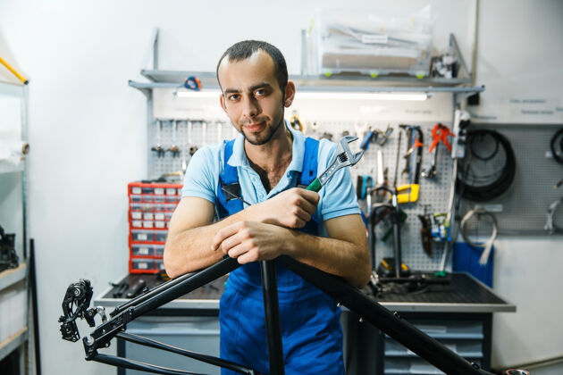 齿轮修理自行车的车间里 男人在车架前摆姿势特写服务工作