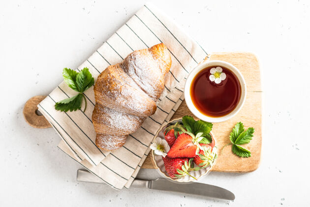 托盘牛角包 茶和牛奶草莓早餐 早春概念 俯瞰放松饮料浆果
