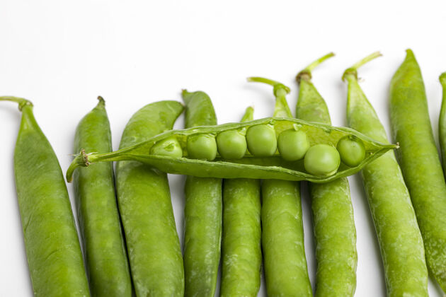 饮食绿豌豆荚 绿豌豆 白色的表面健康豆荚收获