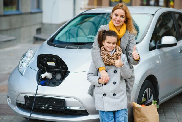 生活方式时尚母女为电动车充电 共度时光电子驾驶员妇女