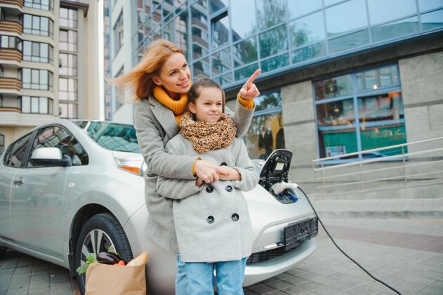 母亲时尚母女为电动车充电 共度时光女性电力千禧一代