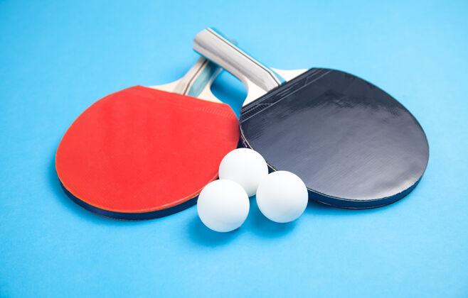 颜色乒乓球拍和蓝色背景上的白色塑料球休闲活动乒乓球
