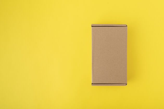 运输黄色背景顶部的纸板箱视图.craft包装.复印件空格.mock起来集装箱纸箱纸板