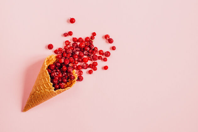 复制空间区域粉红色背景上的华夫饼杯中冷冻葡萄干的俯视图水果文本复制空间红色浆果